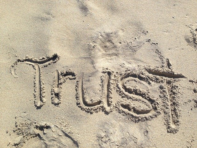 Надпись Trust на песке