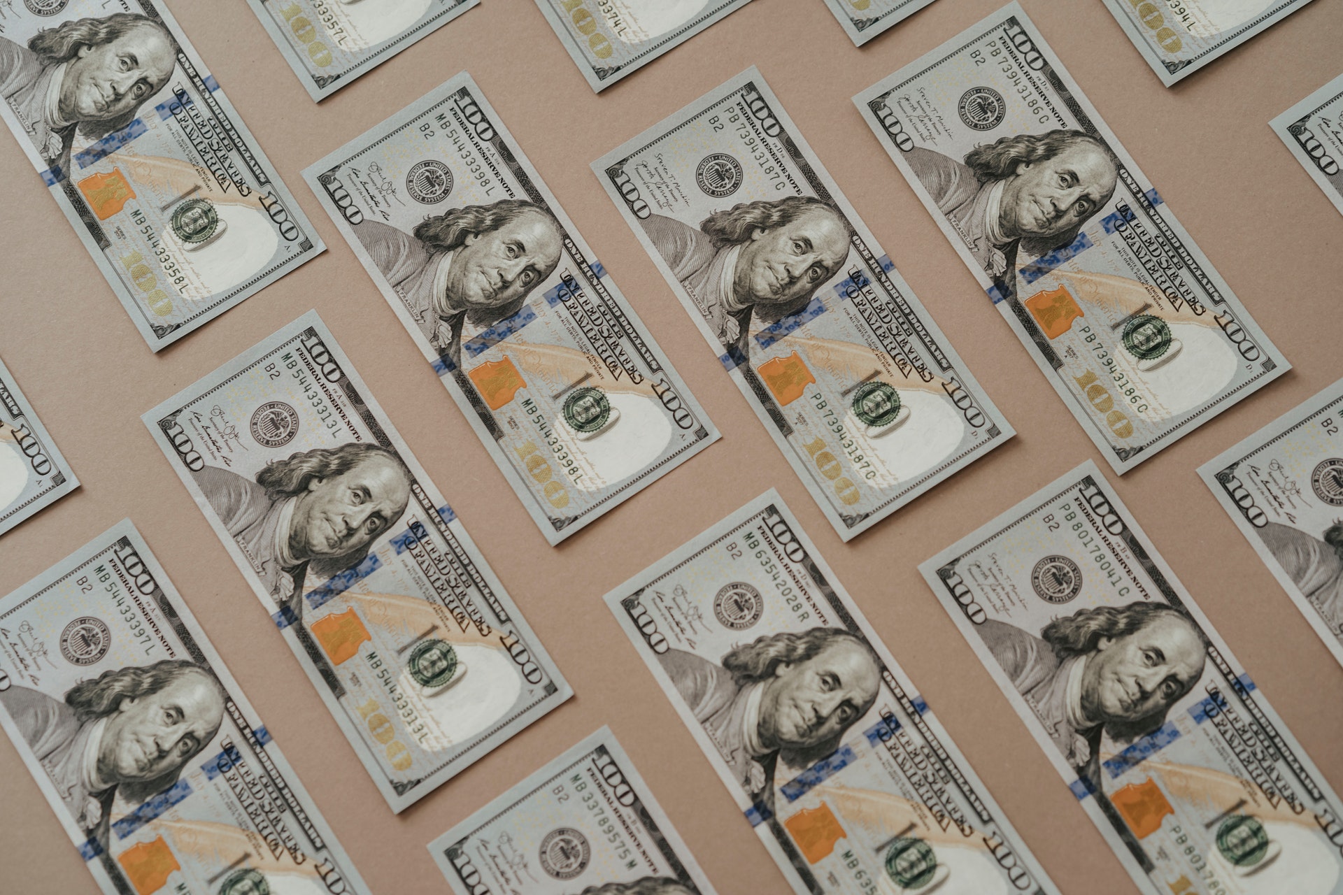 100$ купюры на бежевом фоне
